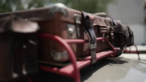 Vintage suitcase on oldtimer car rooftop carrier during a sunny outdoor adven Stock Footage 312951795