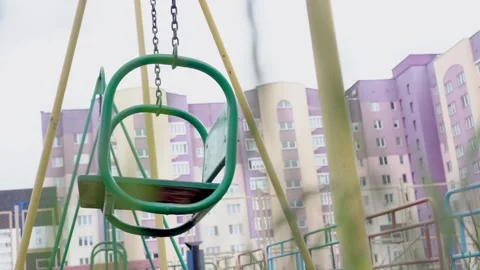 Vintage swing waves on rusty chains against local buildings Stock-Footage 134905113