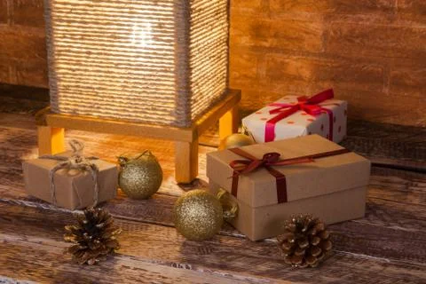 Vintage table lamp, gift boxes and colored christmas balls on wooden background Stock Photos