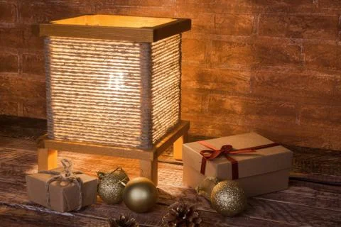 Vintage table lamp, gift boxes and colored christmas balls on wooden background Stock Photos