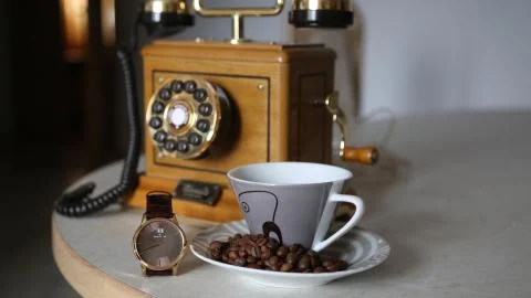 Vintage Telephone and a cup of coffe in the kitchen. Time goes Stock Photos