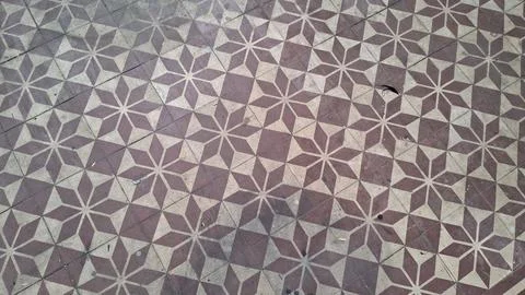 Vintage tile floor featuring a repeating brown and beige star pattern Stockfoto's