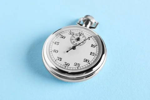 Vintage timer on light blue background. Measuring tool Stock Photos