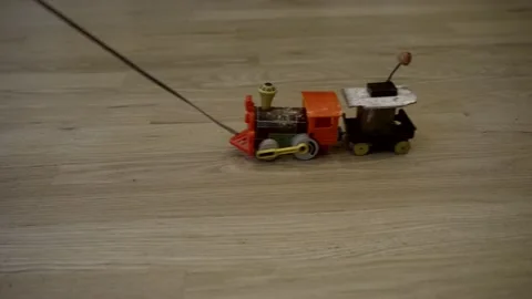 Vintage toy train being pulled on a string on a wooden floor - isolated Video stock 228585280