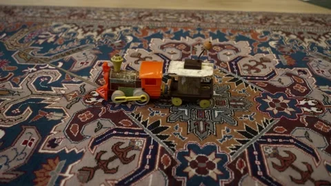 Vintage toy train being pulled across a carpet - isolated close up Video stock 228585338