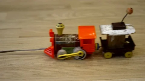 Vintage toy train being pulled across a hardwood floor - isolated close up Video stock 228585362