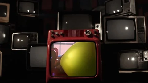 Vintage TV Explodes With Man Inflating Yellow Balloon on Screen - Close Up	 스톡 동영상 117571727