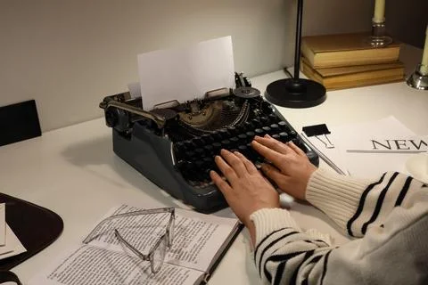 Vintage typewriter with hands typing on blank paper, creative writing and jou Stock Photos