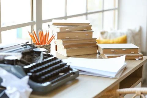 Vintage typewriter with script, books and crumpled paper on desk in screenwri Stock Photos