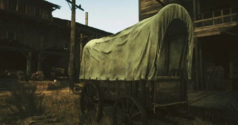 Vintage wagon resting in a rustic western town at sunset Stock Footage 315659172