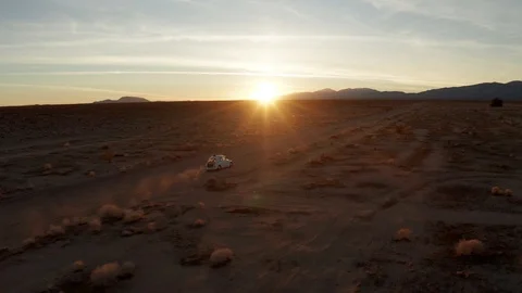 Vintage white car driving through Mojave Desert at sunrise, Aerial Chase Stock Footage