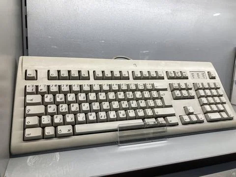 Vintage white computer keyboard displayed against a reflective surface in App 库存照片