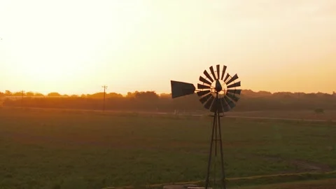 A vintage windmill stands in the foreground in Texas at sunrise. Vidéo 248132876
