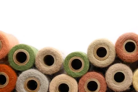 Vintage yarn spools bordering white background Stock Photos