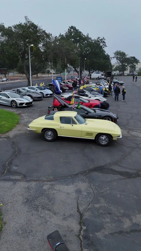 Vintage yellow Corvette Sting Ray at classic car meet, drone shot Stock Footage 346731476