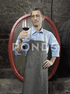 A vintner studying red wine in a glass Stock Photos