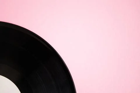 Vinyl disk on pink background with copy space. Vinyl record, close up. Stock Photos