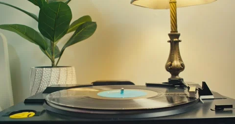 Vinyl player on the table with an old lamp, listen to music on old vinyl records Stock Footage 241515928