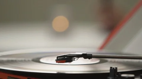 Vinyl playing music while couple holding hands together in background Stock Footage 108546940