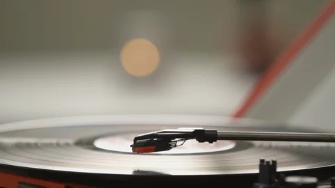 Vinyl playing music while couple holding hands together in background Stock Footage 108547079