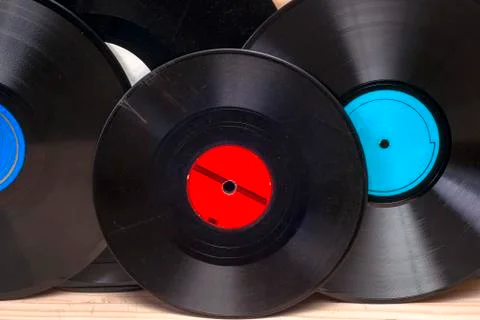 Vinyl record in front of a collection of albums, vintage process. Stock Photos