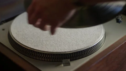 A vinyl record gets placed on a turntable and starts listening to music Stock Footage 134268886