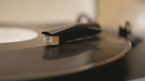 A vinyl record is played in the player Stockbeeldmateriaal 125806579