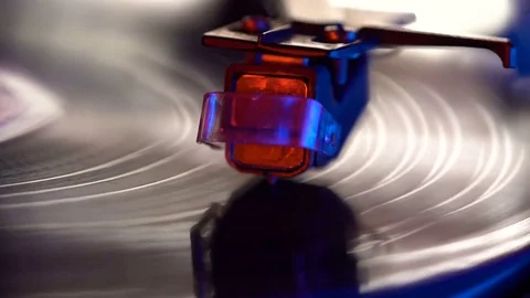 Vinyl record player, bright lights disco-bokeh. Needle on vinyl record. 4K Stock Footage 85353574