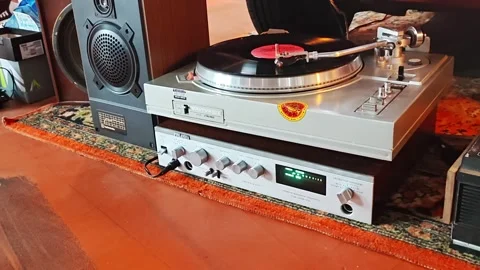 A vinyl record player has been thoughtfully arranged in a cozy home living area, Stock Footage 347010503