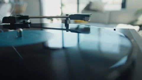 Vinyl record player needle playing music on turntable in living room Stock Footage 307602580
