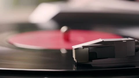 Vinyl record spinning with clear needle and red label in a sunny day Stock Footage 281953220