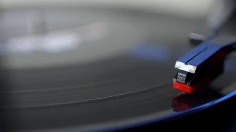 Vinyl record spinning on turntable with needle cartridge close up. 库存影片 340036131