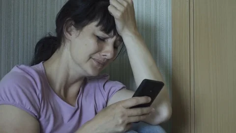 Violence in family. Young raped woman is crying while sitting on floor in cor Stock Footage