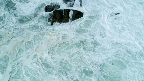 Violent ocean waves churning around dark rocks The Concept of natural power Video stock 336096815