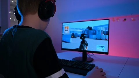 Violent online video game on pc played by a kid wearing a headset Stock Footage 100786718
