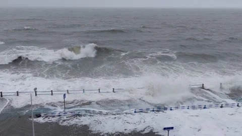 Violent sea waves crash against waterfront road as typhoon approaches coastal Stock Footage 340856747