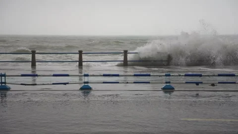 Violent sea waves crash against waterfront road as typhoon approaches coastal Stock Footage 340856847