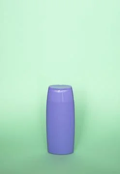 Violet blank shampoo bottle or shower gel on pastel green background. Container Stock Photos