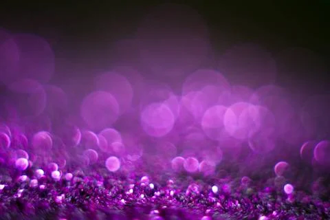 Violet bokeh on a black background. Defocused. Abstract background for you... Stock Photos