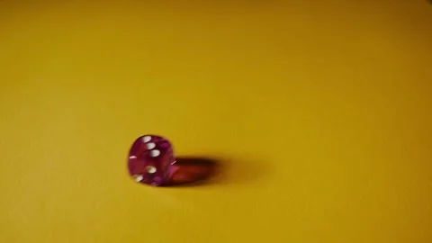 Violet dice fall in slow motion at yellow paper background. Cardboard background Video stock 288769818