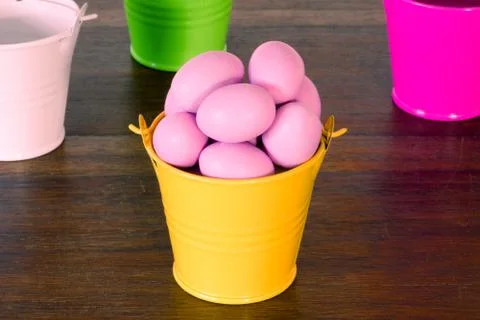 Violet easter eggs in a yellow bucket Stock Photos
