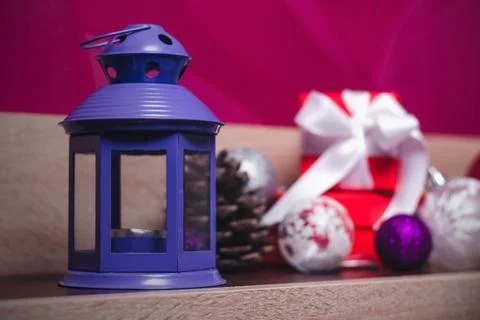 Violet old aromatic lamp on the background of Christmas decorations and gifts Stock Photos