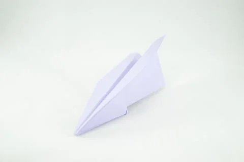 Violet paper plane on a white background, isolated. Concept (idea) of airline Stock Photos