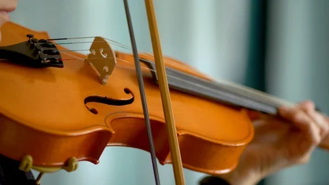 Violin and bow in hands of a young female violinist. Close up view Stock Footage 129573668