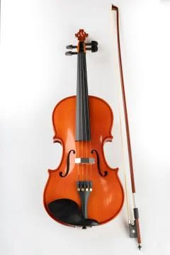Violin and bow on a light background. A new stringed musical instrument. Stock Photos
