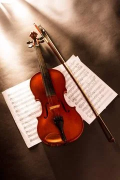 Violin and notes Violin with bow and handdrawn notes under dramatic light ... Stock Photos