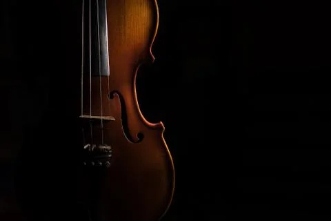 Violin on a black background lit from one side Stock Photos