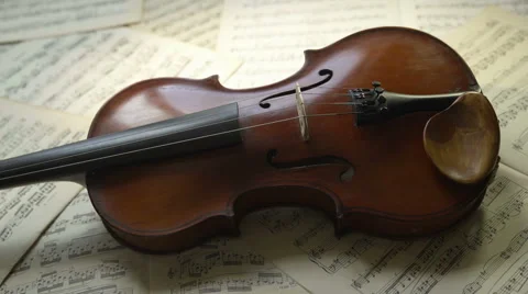 Violin body lying on musical notes background. Romantic lighting, 4K, UHD, 24fps Stock Footage 65417019
