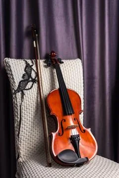 Violin with bow on empty chair Stock Photos