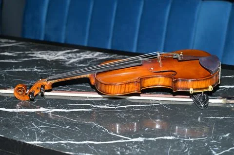 A violin with a bow lies on the table Stock Photos
